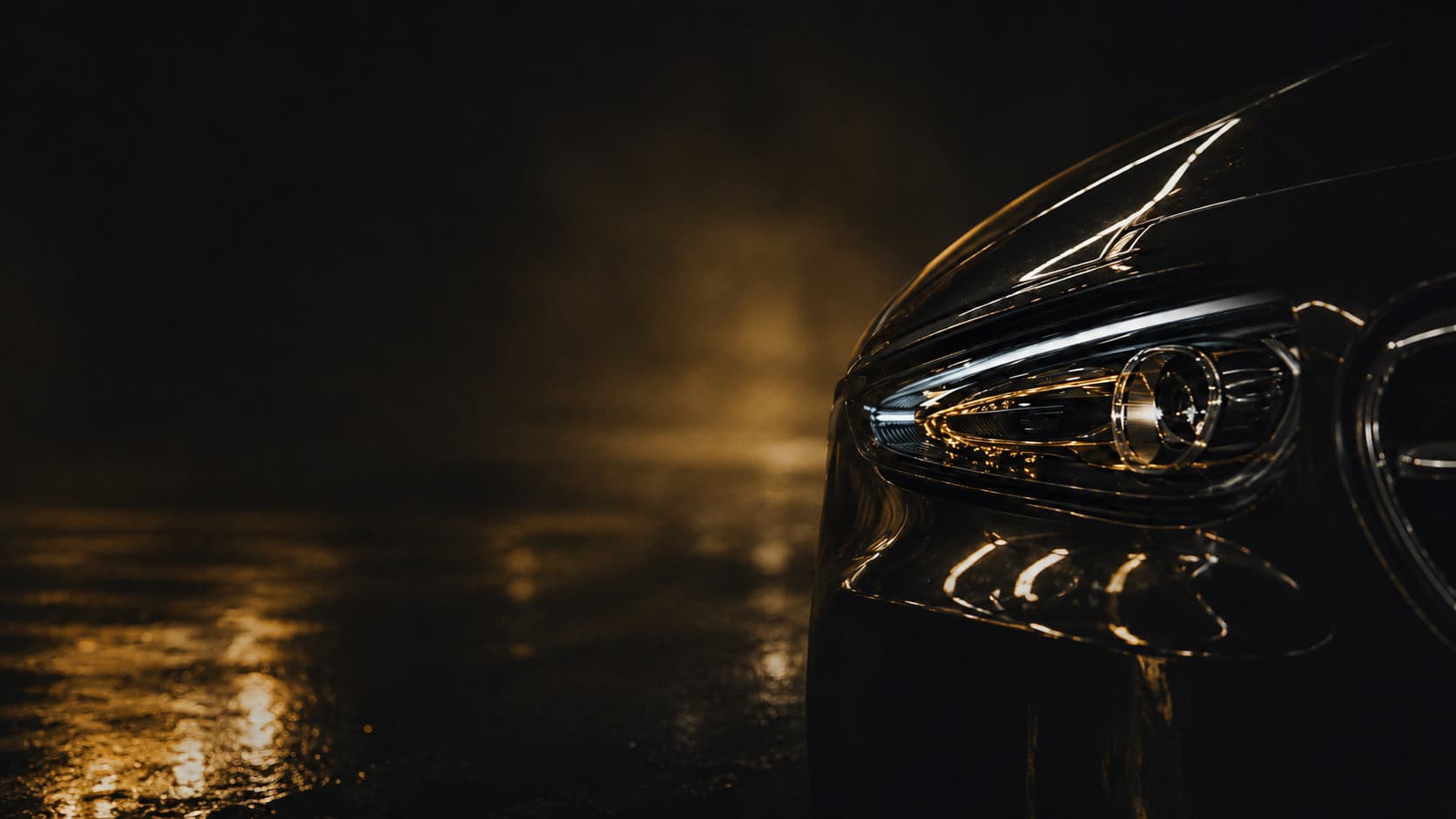Faro de un coche de lujo brillando en una calle mojada de noche